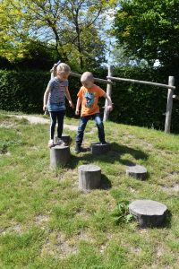 kinderen op stapstenen in het gras